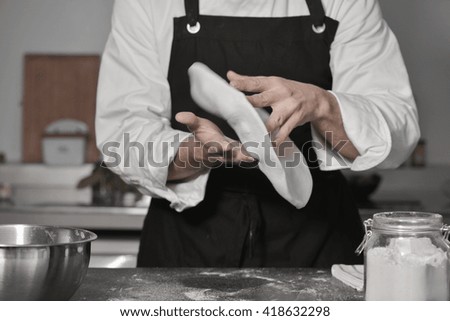 Chef cooking pizza in kitchen with hands