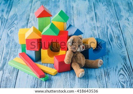 shot of pile of various wooden blocks and toy bear