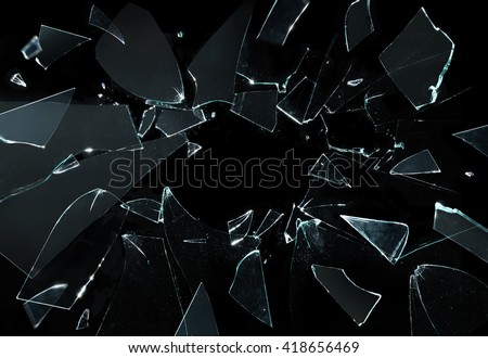 Shattered and broken glass pieces isolated on black Royalty-Free Stock Photo #418656469