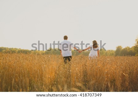 romantic happy couple go on a wheat field. Standing and hugging. They love each other, not gay. Spending time together, family values.