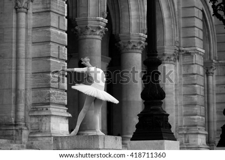 Graceful ballerina in white tutu dancing in front of a palace