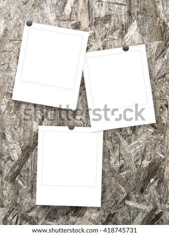 Close-up of three blank instant photo frames with pins on wooden background