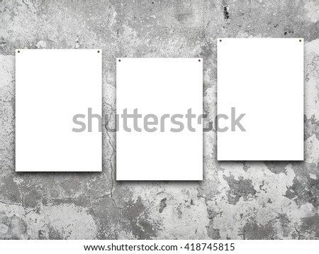 Close-up of three nailed asymmetrical blank frames on stained wall background