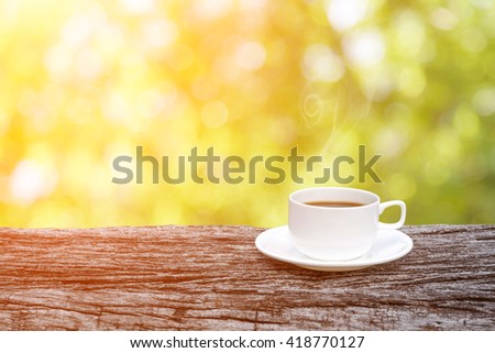 coffee cup on old wooden over abstract nature background.