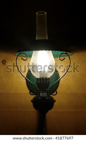 Green wall lamp on the wooden wall