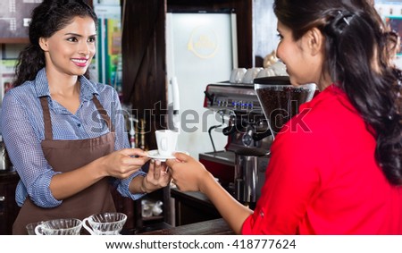Bartender serving customer in Indian cafe