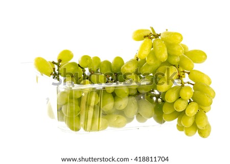 Close up green grapes in a  plastic box on a white background