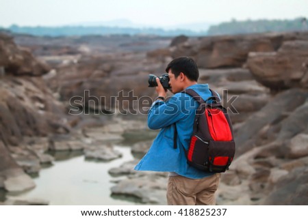 blurry of A man asia with backpack taking a photo on the top of mountains ,soft focus 