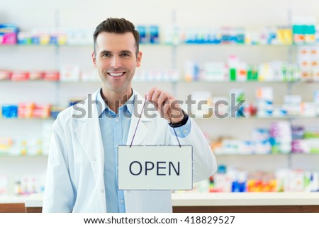 Pharmacist Holding An Open Sign
