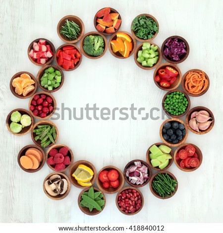 Paleo diet health and super food of fruit and vegetables in wooden bowls forming an abstract wheel over distressed white wood background. High in vitamins, antioxidants, minerals and anthocyanins. Royalty-Free Stock Photo #418840012
