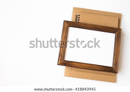 blank wood picture frame, book on the table / can be used for your text or artwork / Top view