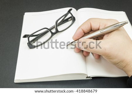 a person beginning to write on a blank book
