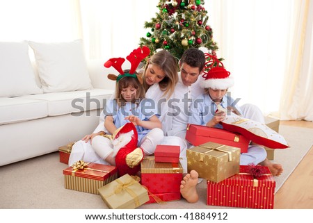 Portrait of a happy family opening gifts at Christams time