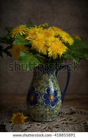 Bunch of yellow dandelions in a jar. Selective focus, toned image and the effect of antiquity