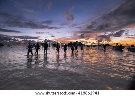Silhouette a row of photographer with dramatic sunrise moment in Mabul Island, Semporna Sabah