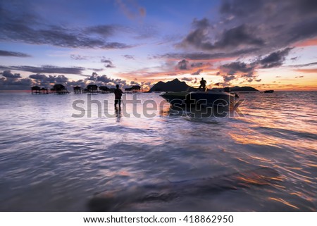 Silhouette a row of photographer with dramatic sunrise moment in Mabul Island, Semporna Sabah