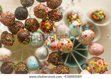 Toned image of decorated cake pops and candies on table