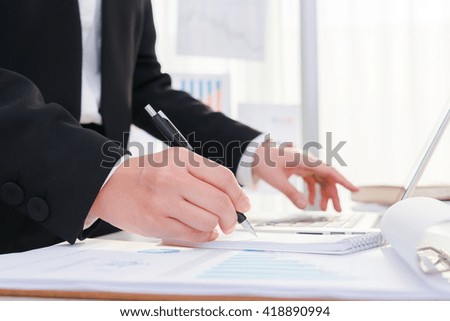 Business people using a pencil noting over laptop