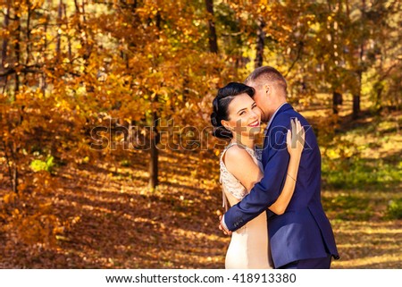 The bride and groom in autumn park. Love story. Young, happy couple.