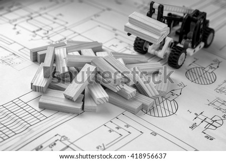 Toy construction machine builds model of house from wooden blocks (bars) at the drawings.