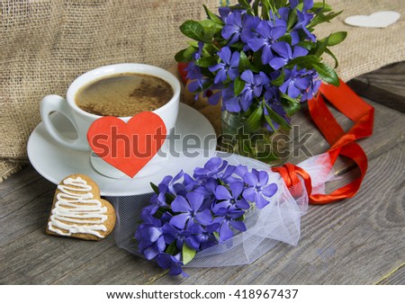 Coffee mug with Vinca flowers and notes for text. Romantic date, invitation, sweet wish concept.  toned image.
