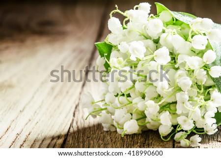 Bouquet of may forest lily of the valley, vintage wooden background, selective focus