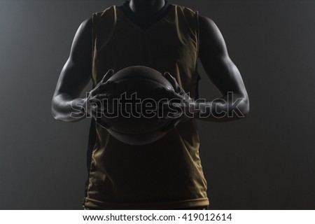 Close up on basketball player holding a ball on a gym