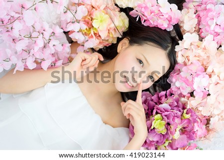 Girl in flower hand point to nose