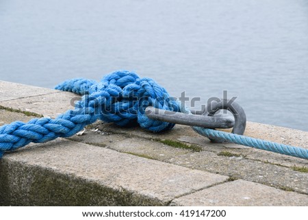Knot and Ship anchored to ropes tied to the dock of fisher boat