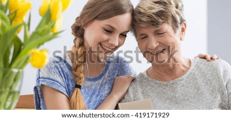 Shot of a young woman and her grandmother looking at a picture
