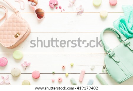 Pastel theme mood board with fashion accessories (bag, sunglasses, scarf) for girls. White rustic wooden background. Flat lay composition (from above, top view). Free text space.