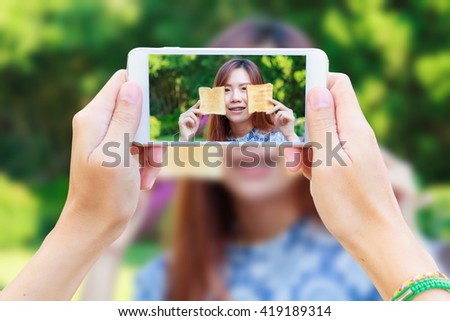 Hand man with Smartphone taking a picture of Asia girl teenage and breakfast in the resort.