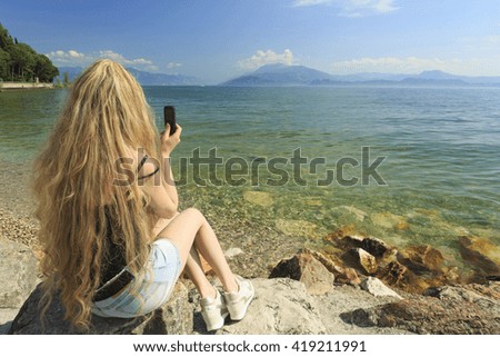 Woman with cell phone on the lake