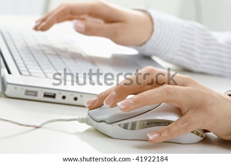 Closeup picture of computer keyboard and female hand using mouse.