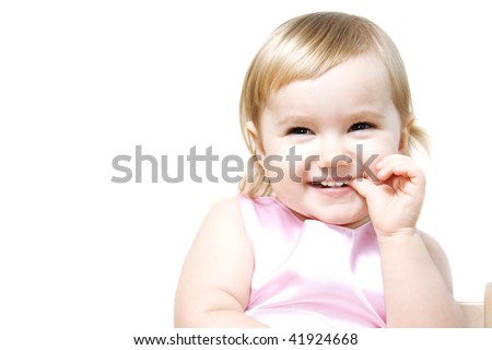 Laughing little girl holding finger in her mouth