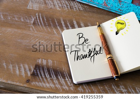 Handwritten text Be Thankful with fountain pen on notebook. Concept image with copy space available.
