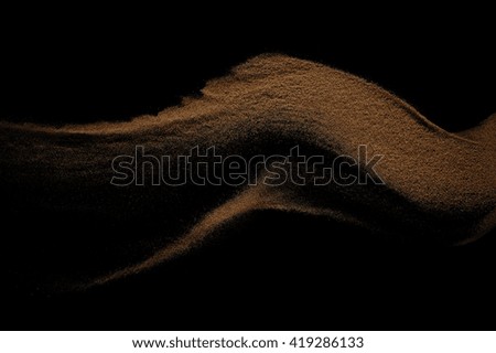 Sandy wave isolated on black background. Abstract sand dune.