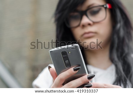 emo girl reads message on mobile phone