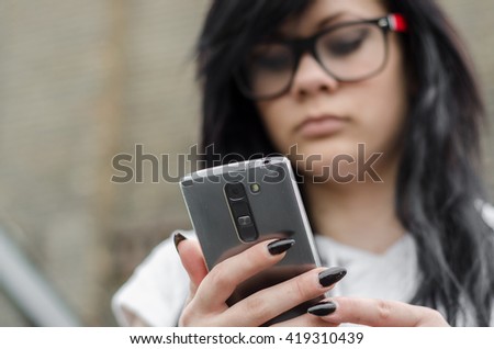 emo girl reads message on mobile phone