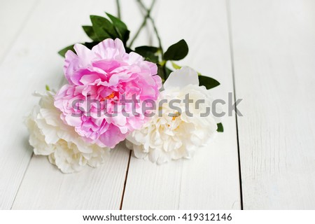 Stunning pink peonies on white rustic wooden background