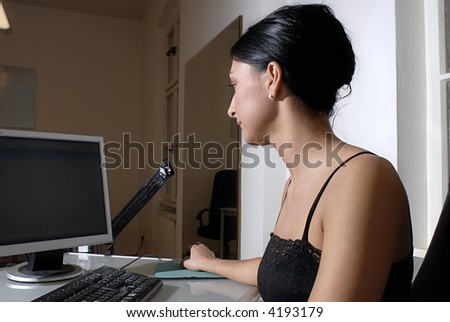 An attractive young adult woman working on her computer.
