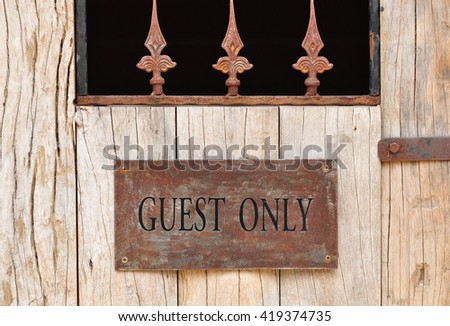 'Guest Only' plate hang on the wood door