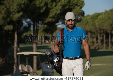 handsome middle eastern golfer  carrying  bag  and walking  to next hole at golf  course