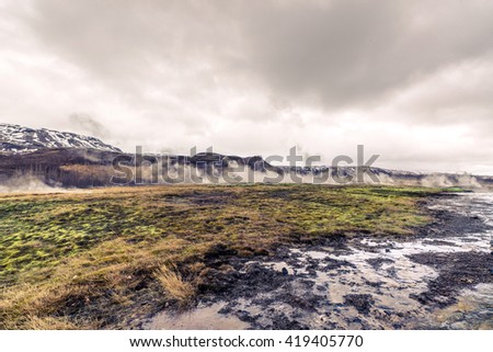 Steamy fields in iceland in cloudy weather
