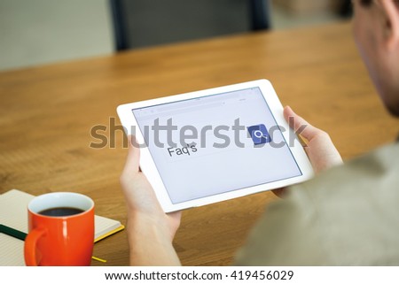 Man searching FAQ'S with tablet pc