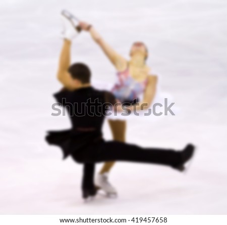 Two skaters dance on ice as background. Unrecognizable people. Intentional blur effect applied