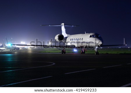 Business jet starting up at night. Royalty-Free Stock Photo #419459233