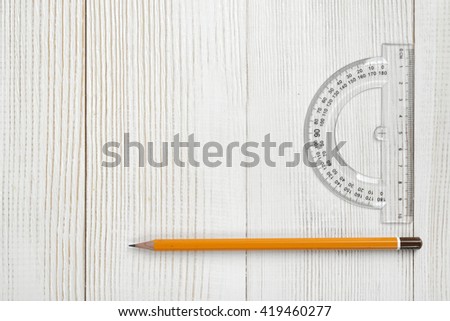 Layout with protractor and pencil on wooden surface. Top view composition. Measuring process. Work place of draftsman, architect, constructor. Engineering work. Construction and architecture. Working