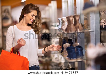 Smiling attractive young women shopping at shoes store Royalty-Free Stock Photo #419471857