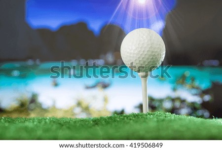 Golf ball on green grass, Background sea.